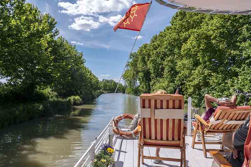 Relax on the sun deck while you cruise along the canal du midi on Hotel Barge Athos