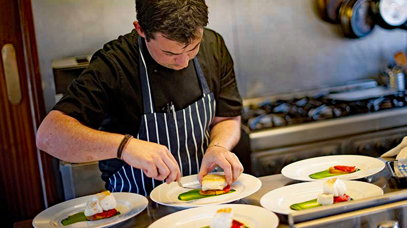 Chef preparing a meal on English Hotel Barge Magna Carta