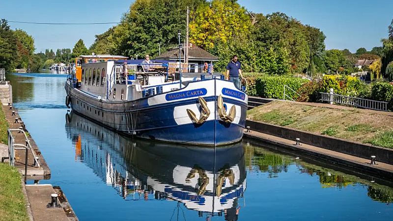 English Hotel Barge Magna Carta entering a lock on the Thames in England