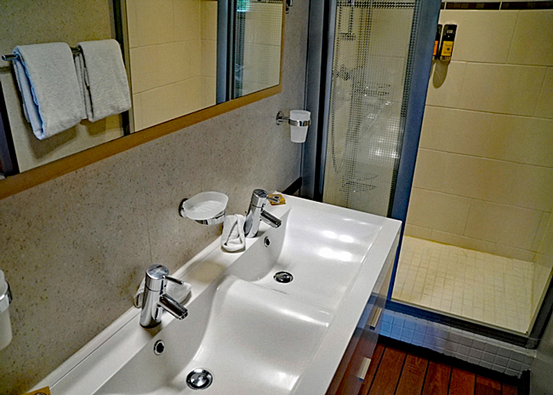 Ensuite bathroom showing with his & her sinks and shower