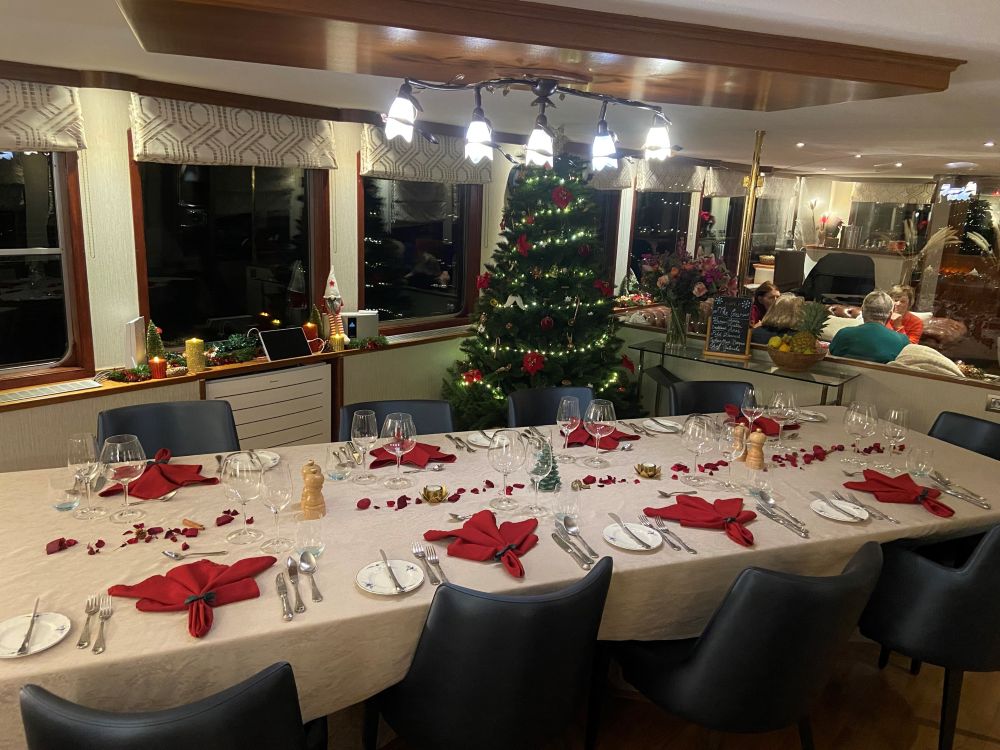 Hotel Barge Panache looking festive during their Christmas Markets Cruise in Alsace France. Christmas tree & decorations and beautiful table setting