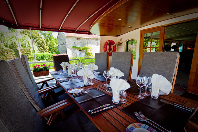 French Hotel Barge Prosperite - Shaded sun deck with table & chairs