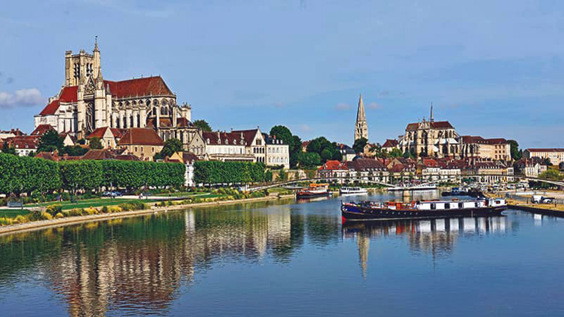 French Hotel Barge L'Art de Vivre moored on the Canal du Centre in Auxerre below the Cathédrale Saint-Étienne d'Auxerre.