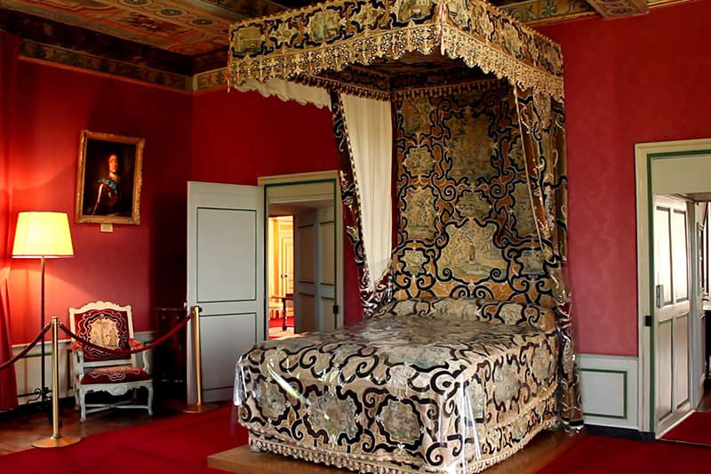 Château de Bazoches - Bed Chamber. Its décor is reflective of the times of King Louis XIV, boasting elegant fabrics, expensive paintings, and extravagant chandeliers. Photo EW