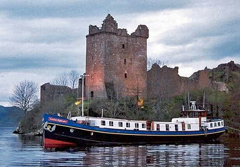 Scottish Hotel Barge Scottish Highlander moored outside of Urquhart castle