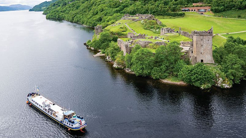 Scottish Hotel Barge Scottish Highlander cruising near Urquhart castle