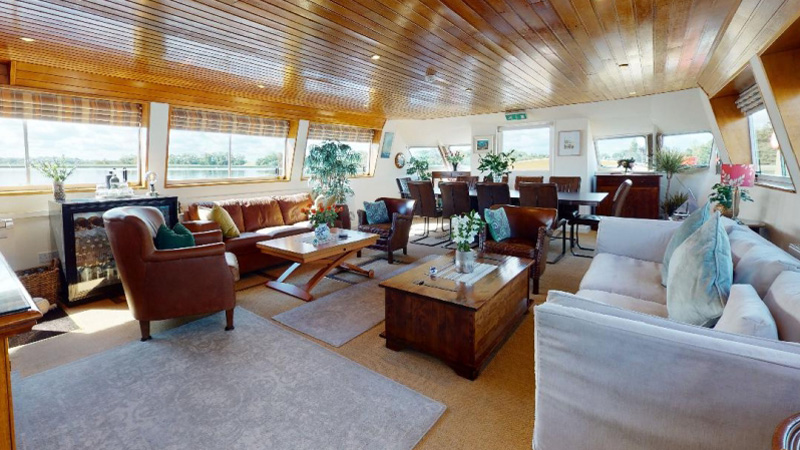 Irish Hotel Barge Shannon Princess has a comfortable salon for 10 passengers with wine cooler, sofas, armchairs, dining area, and panoramic windows