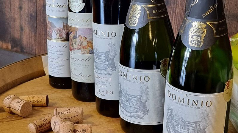 Italy - 5 different Italian wine bottles and their corks on a wooden table. ew
