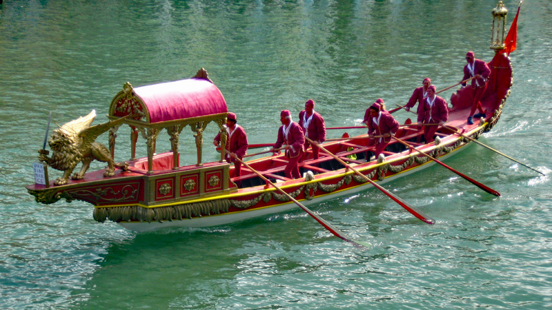 Venice, Italy - Regata Storica - Red boat with gold trim with gold lion on bow. Photo: Wikimedia Commons - Godromil - public domain
