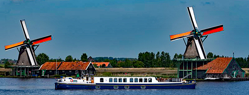 Header image for Barging in Holland - Dutch Hotel Barge Panache cruising past windmills in Holland